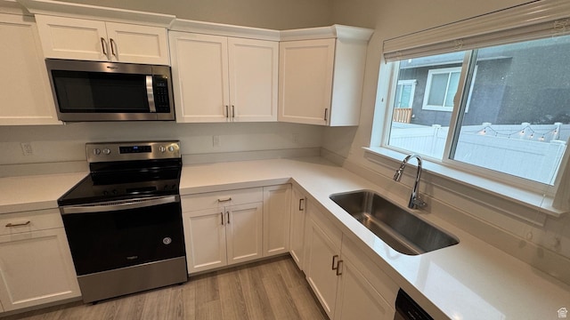 427 E 340 N, Vineyard, UT 84059 - kitchen with stainless steel appliances, white cabinets, light countertops, and light wood-style flooring