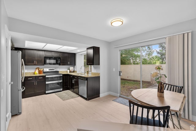 2039 E Rainbow Point Dr, Holladay, UT 84124 - kitchen with stainless steel appliances, light wood-type flooring, light stone counters, and dark brown cabinetry