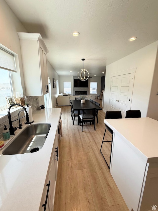 1258 E Bell Buoy Way, Eagle Mountain, UT 84005 - kitchen featuring open floor plan, white cabinetry, recessed lighting, light wood-style flooring, and light countertops