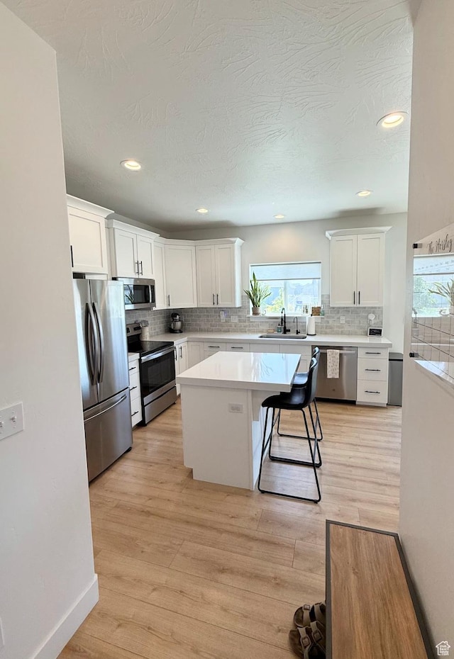1258 E Bell Buoy Way, Eagle Mountain, UT 84005 - kitchen featuring appliances with stainless steel finishes, decorative backsplash, white cabinetry, light countertops, and recessed lighting