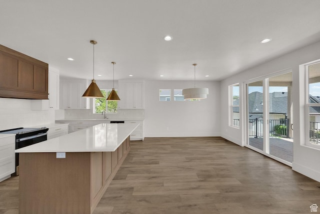 761 W 880 N, American Fork, UT 84003 - kitchen featuring electric range, decorative backsplash, light countertops, light wood finished floors, and a center island