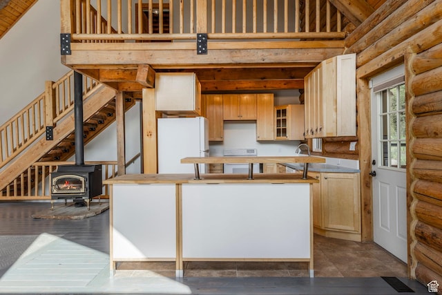 1796 W Tollgate Canyon Rd, Wanship, UT 84017 - kitchen featuring freestanding refrigerator, rustic walls, high vaulted ceiling, a wood stove, and a center island