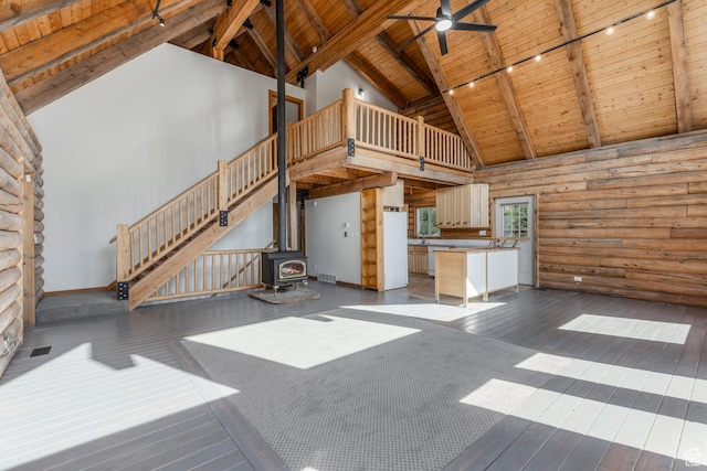 1796 W Tollgate Canyon Rd, Wanship, UT 84017 - unfurnished living room with a wood ceiling with exposed beams, high vaulted ceiling, a wood stove, log walls, and hardwood / wood-style floors