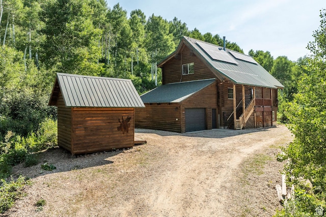 1796 W Tollgate Canyon Rd, Wanship, UT 84017 - view of front of house featuring stairs, a detached garage, a metal roof, driveway, and a storage unit