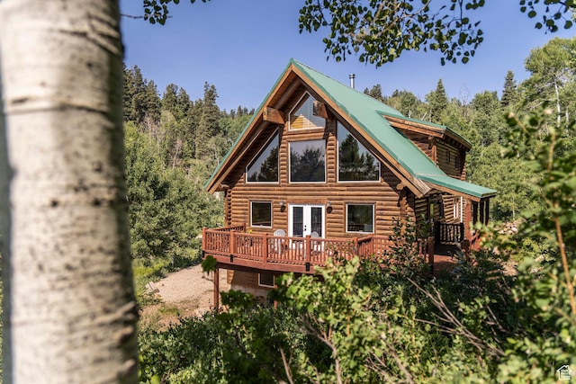 1796 W Tollgate Canyon Rd, Wanship, UT 84017 - back of property featuring log siding, a wooden deck, french doors, a metal roof, and a wooded view