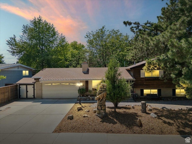 6690 S 1495 E, Cottonwood Heights, UT 84121 - tri-level home with a garage, driveway, a chimney, and brick siding