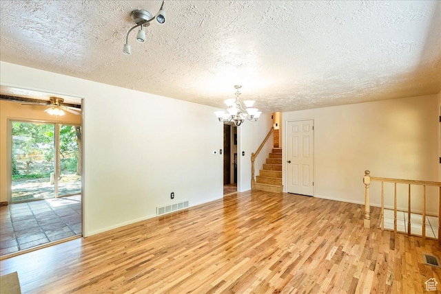 6690 S 1495 E, Cottonwood Heights, UT 84121 - unfurnished room featuring wood finished floors, a chandelier, a textured ceiling, and stairs