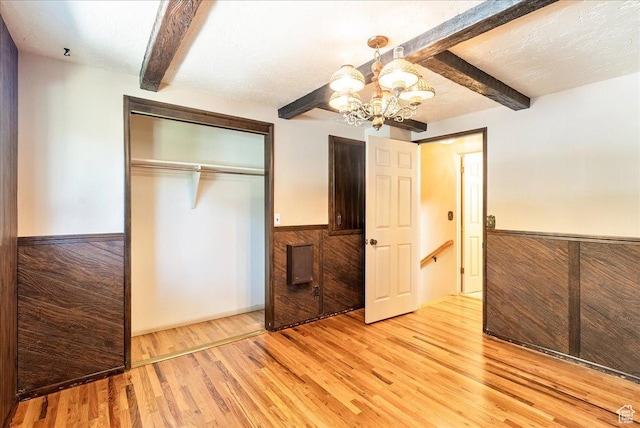 6690 S 1495 E, Cottonwood Heights, UT 84121 - unfurnished bedroom with beam ceiling, a chandelier, light wood-type flooring, a closet, and wainscoting