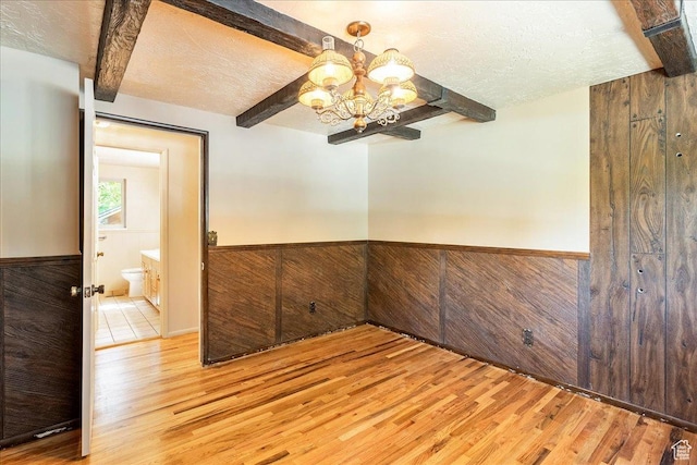 6690 S 1495 E, Cottonwood Heights, UT 84121 - spare room featuring beam ceiling, light wood-style floors, a chandelier, a wainscoted wall, and a textured ceiling