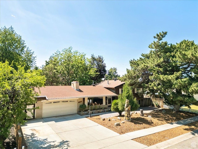 6690 S 1495 E, Cottonwood Heights, UT 84121 - view of front facade featuring an attached garage, concrete driveway, and a chimney
