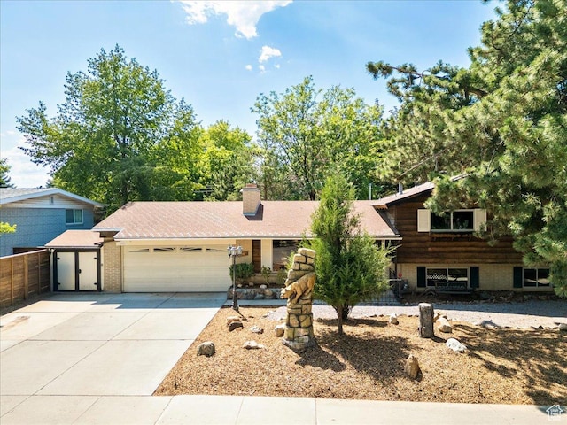 6690 S 1495 E, Cottonwood Heights, UT 84121 - split level home with an attached garage, concrete driveway, and a chimney