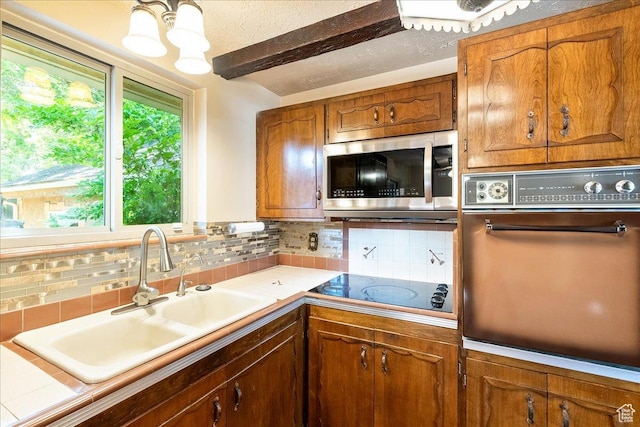 6690 S 1495 E, Cottonwood Heights, UT 84121 - kitchen featuring stainless steel microwave, oven, decorative backsplash, brown cabinets, and beamed ceiling