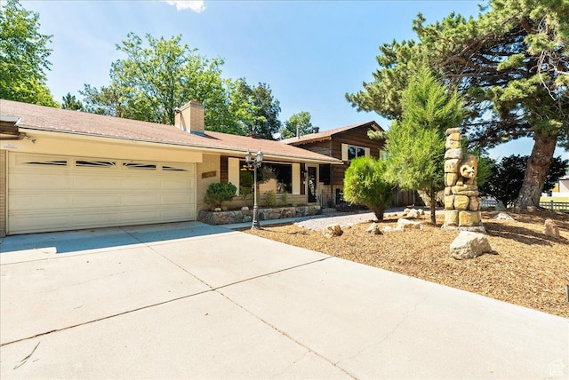 6690 S 1495 E, Cottonwood Heights, UT 84121 - split level home featuring concrete driveway, a garage, and a chimney
