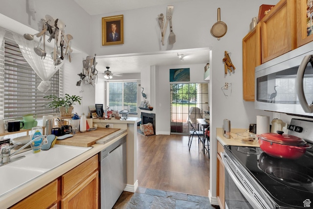 1380 W Ocean Ct, Salt Lake City, UT 84123 - kitchen with stainless steel appliances, light countertops, a ceiling fan, wood finished floors, and brown cabinets