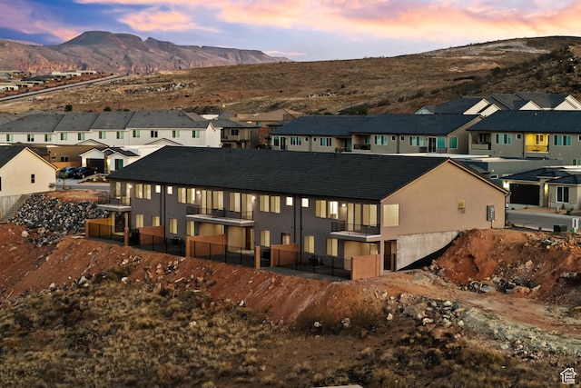 2162 W 320 S Unit 51, Hurricane, UT 84737 - back of house at dusk with a residential view, a mountain view, and stucco siding