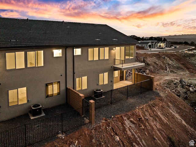 2162 W 320 S Unit 51, Hurricane, UT 84737 - back of property at dusk with a balcony, a fenced backyard, stucco siding, and a patio
