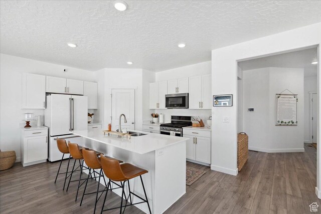 1128 E Bearing Dr S, Saratoga Springs, UT 84045 - kitchen with stainless steel appliances, a kitchen breakfast bar, light countertops, a textured ceiling, and a kitchen island with sink