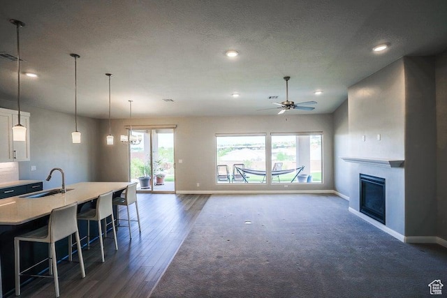 621 N Sage Hen Dr, Washington, UT 84780 - living area with recessed lighting, ceiling fan, a glass covered fireplace, dark wood-style flooring, and dark colored carpet