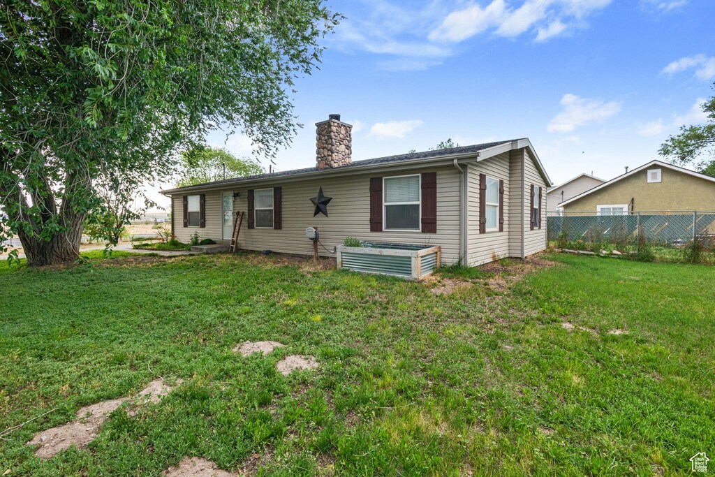 7194 W Schuler Ave, West Valley City, UT 84128 - rear view of property with a chimney