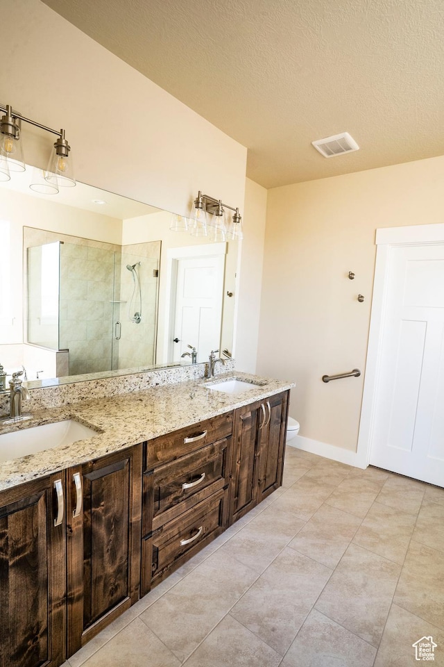 3966 W 2025 S Unit 29, Taylor, UT 84401 - bathroom with a shower stall, double vanity, tile patterned flooring, and a textured ceiling