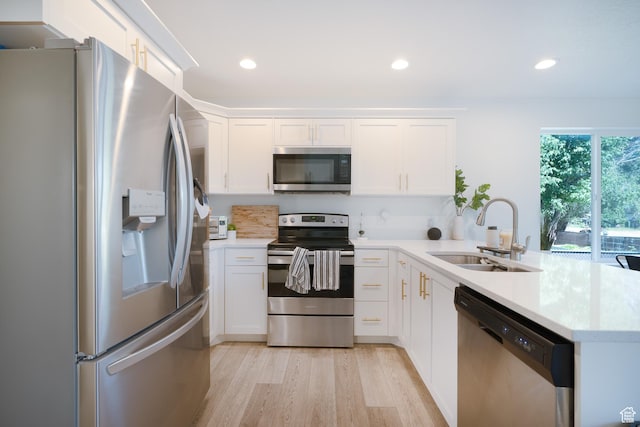 1065 W 200 N, Provo, UT 84601 - kitchen with stainless steel appliances, a peninsula, light wood finished floors, white cabinets, and light countertops