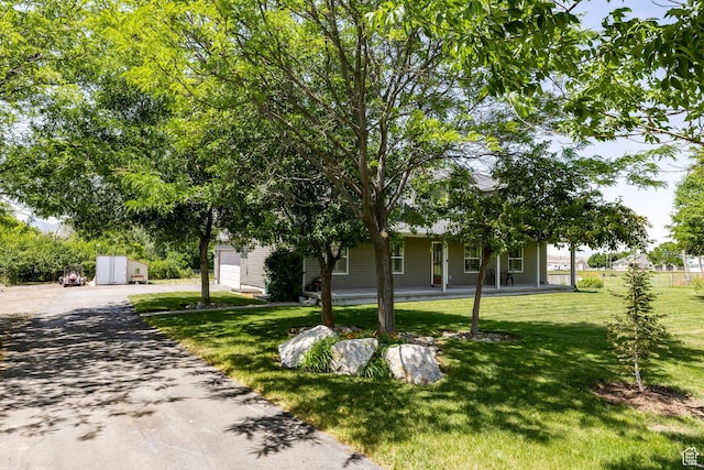 8871 S 100 E, Paradise, UT 84328 - view of property hidden behind natural elements with asphalt driveway, a front yard, and a porch