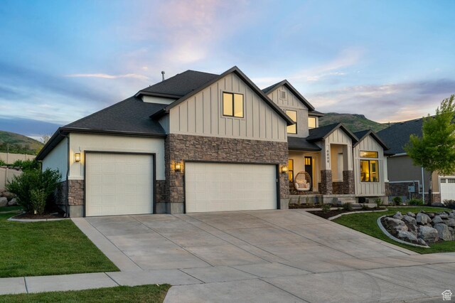 6809 W Vista Springs Dr, Herriman, UT 84096 - view of front of house featuring stone siding, an attached garage, driveway, board and batten siding, and a front yard