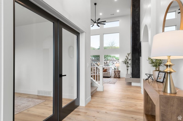 6809 W Vista Springs Dr, Herriman, UT 84096 - hall featuring wood finished floors, a towering ceiling, recessed lighting, french doors, and stairway