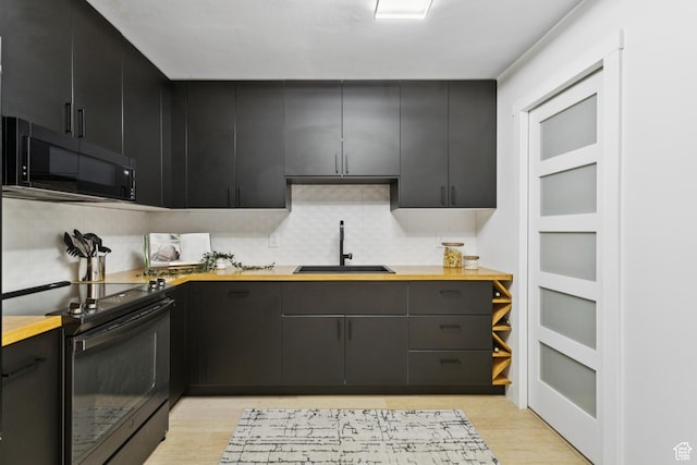 123 E 2nd Ave Unit 505, Salt Lake City, UT 84103 - kitchen featuring black appliances, light wood-style floors, dark cabinets, butcher block counters, and tasteful backsplash