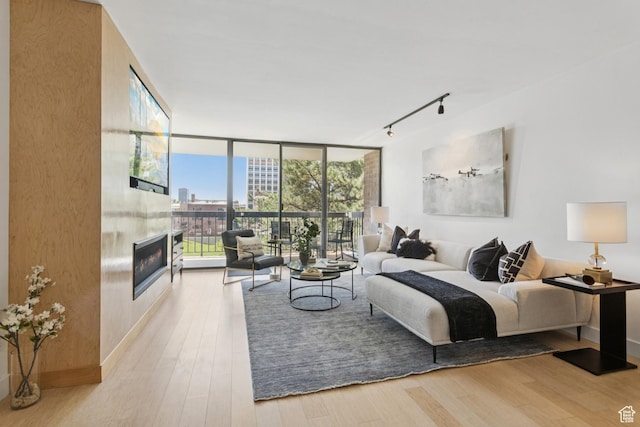 123 E 2nd Ave Unit 505, Salt Lake City, UT 84103 - bedroom with expansive windows, rail lighting, a fireplace, wood finished floors, and access to exterior