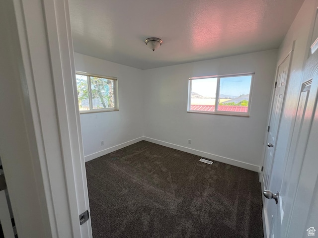 2955 N 7600 W, Corinne, UT 84307 - unfurnished bedroom with dark carpet and baseboards