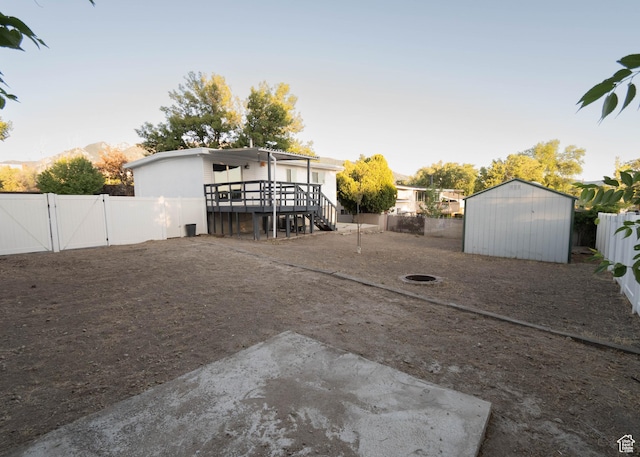 9446 S Barium St E, Sandy, UT 84094 - fenced backyard with a gate, a deck, a storage unit, and a patio