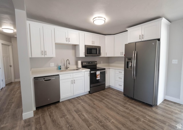 9446 S Barium St E, Sandy, UT 84094 - kitchen with appliances with stainless steel finishes, wood finished floors, white cabinets, and light countertops