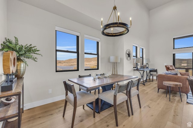 864 W Eland Cir, Heber City, UT 84032 - dining area with a chandelier, light wood-style flooring, and a towering ceiling