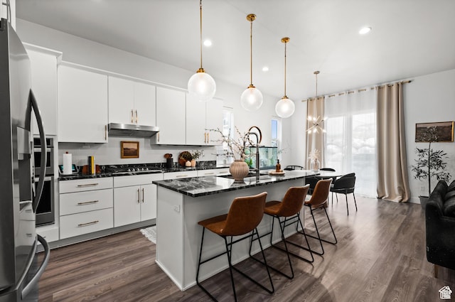 4753 W Mossley Dr, Herriman, UT 84096 - kitchen featuring under cabinet range hood, a breakfast bar area, dark wood-type flooring, a kitchen island, and white cabinets