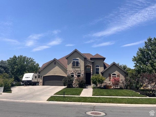 12768 S Whisper Bend Dr E, Draper, UT 84020 - view of front of house with stone siding, a front lawn, concrete driveway, stucco siding, and a garage