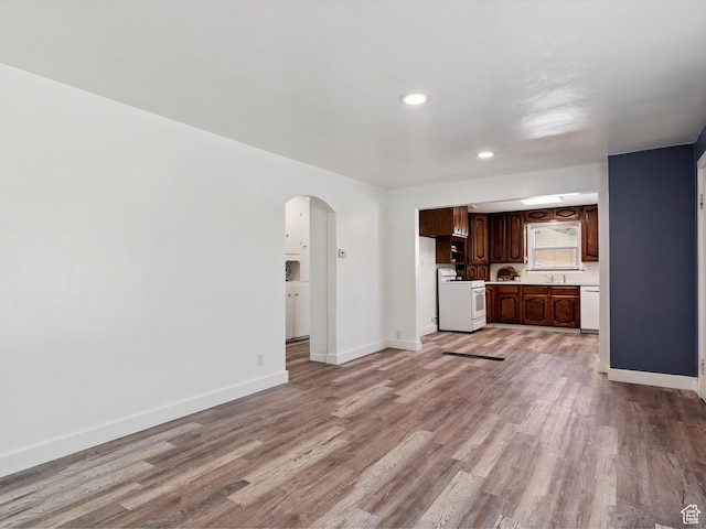 1425 E 22nd St S, Ogden, UT 84401 - unfurnished living room with arched walkways, light wood-style floors, and recessed lighting