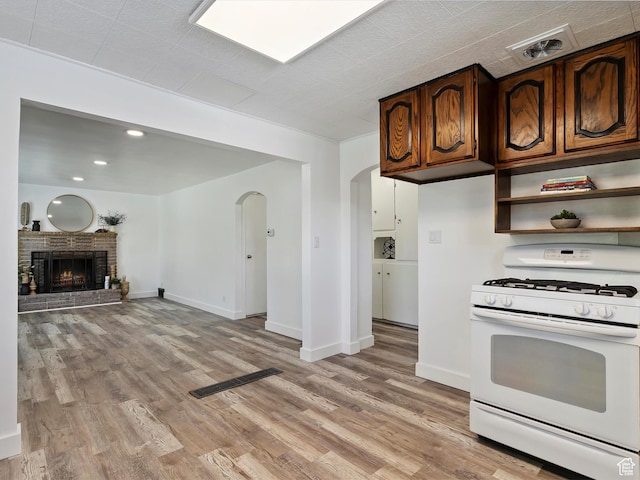 1425 E 22nd St S, Ogden, UT 84401 - kitchen featuring gas range gas stove, arched walkways, light wood-style floors, a fireplace, and open shelves
