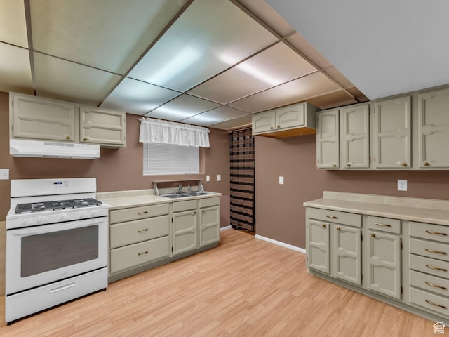 12580 S Janice Dr, Riverton, UT 84065 - kitchen featuring white range with gas stovetop, under cabinet range hood, light wood-style flooring, a paneled ceiling, and light countertops