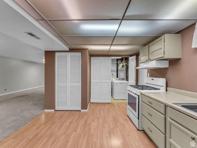 12580 S Janice Dr, Riverton, UT 84065 - kitchen with white gas range oven, washer / clothes dryer, under cabinet range hood, light countertops, and light wood-style flooring