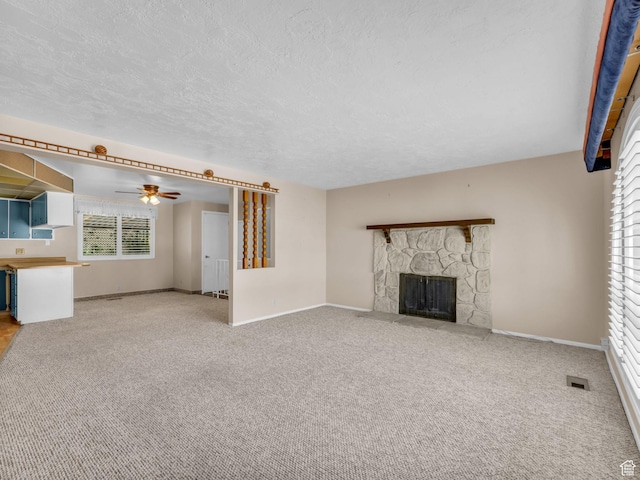 12580 S Janice Dr, Riverton, UT 84065 - unfurnished living room featuring a fireplace, a ceiling fan, carpet flooring, healthy amount of natural light, and a textured ceiling