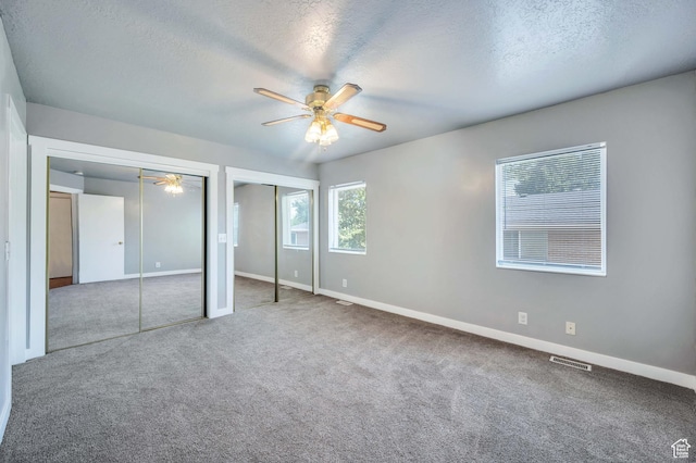 4940 S Atwood Blvd, Murray, UT 84107 - unfurnished bedroom featuring two closets, carpet flooring, a textured ceiling, and ceiling fan