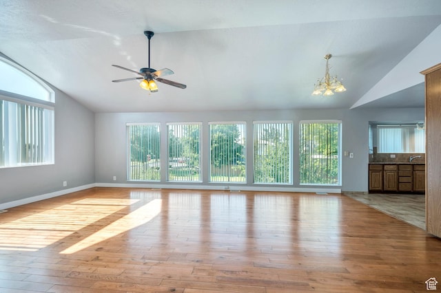 4940 S Atwood Blvd, Murray, UT 84107 - unfurnished living room featuring lofted ceiling, healthy amount of natural light, light wood-style flooring, a chandelier, and ceiling fan