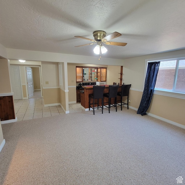 5272 S 1035 E, South Ogden, UT 84403 - dining area featuring a textured ceiling, a ceiling fan, light carpet, bar, and light tile patterned floors