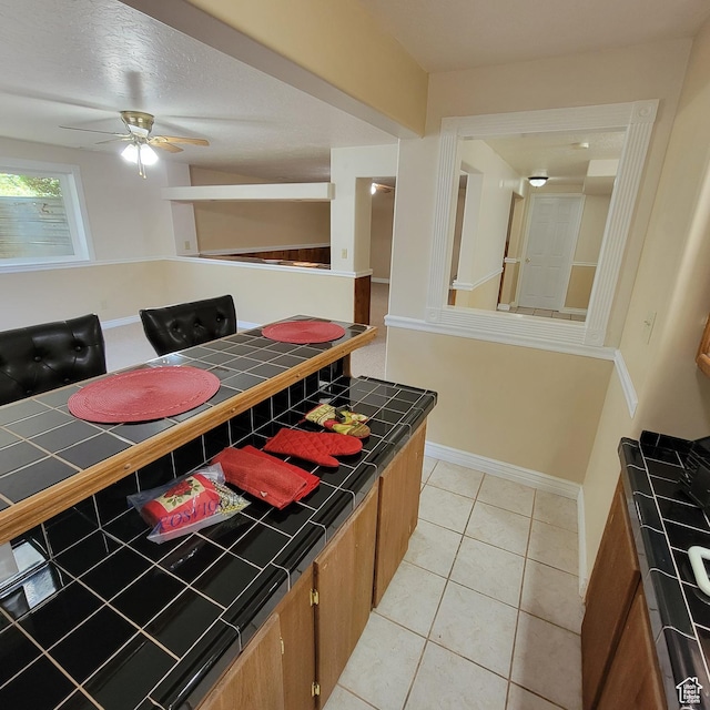5272 S 1035 E, South Ogden, UT 84403 - kitchen featuring tile countertops, brown cabinetry, ceiling fan, and light tile patterned flooring