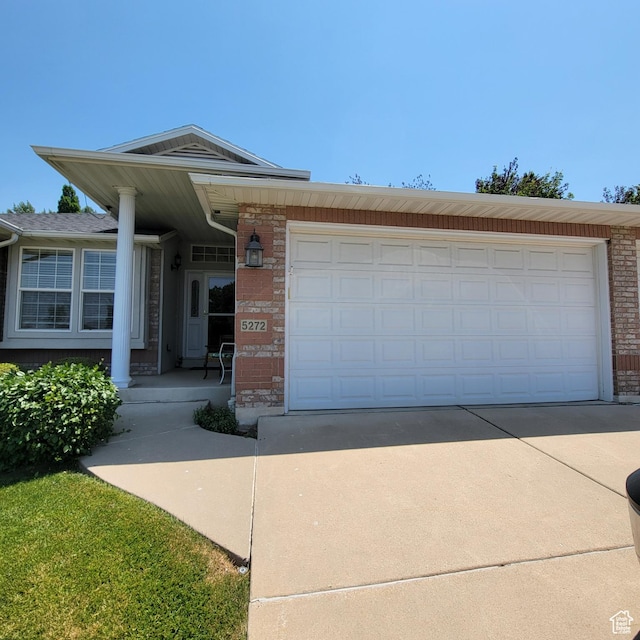 5272 S 1035 E, South Ogden, UT 84403 - view of front facade with concrete driveway, brick siding, a garage, and a porch