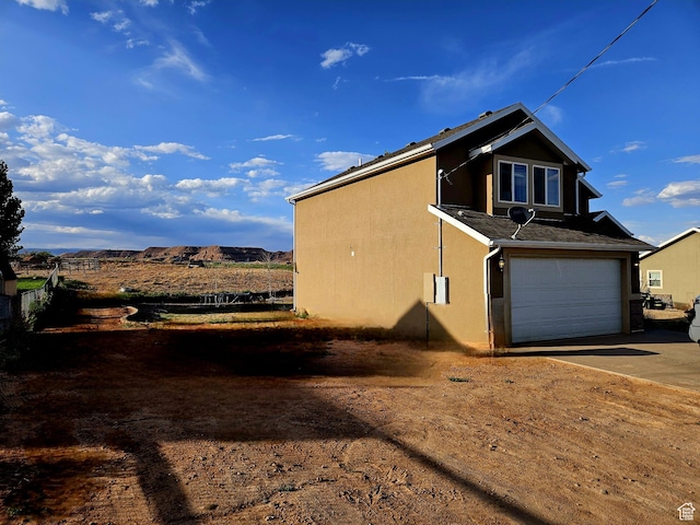 2175 E 1000 N, Ballard, UT 84066 - view of property exterior featuring driveway, an attached garage, and stucco siding