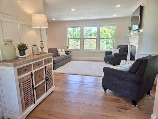 3501 E Golden Eagle Rd N, Eagle Mountain, UT 84005 - living area with a fireplace, hardwood / wood-style flooring, recessed lighting, and a decorative wall