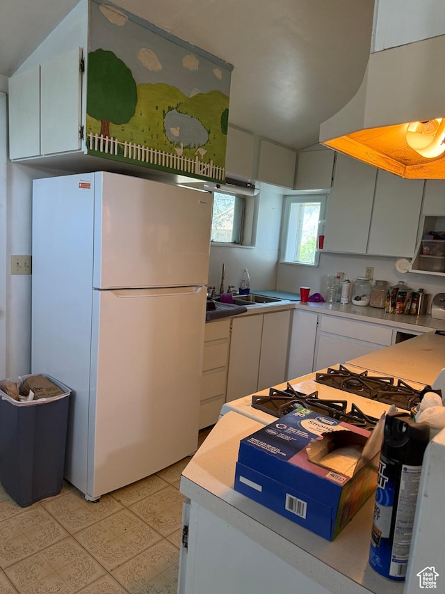 539 E Center St, Pleasant Grove, UT 84062 - kitchen featuring freestanding refrigerator, exhaust hood, vaulted ceiling, and white cabinets