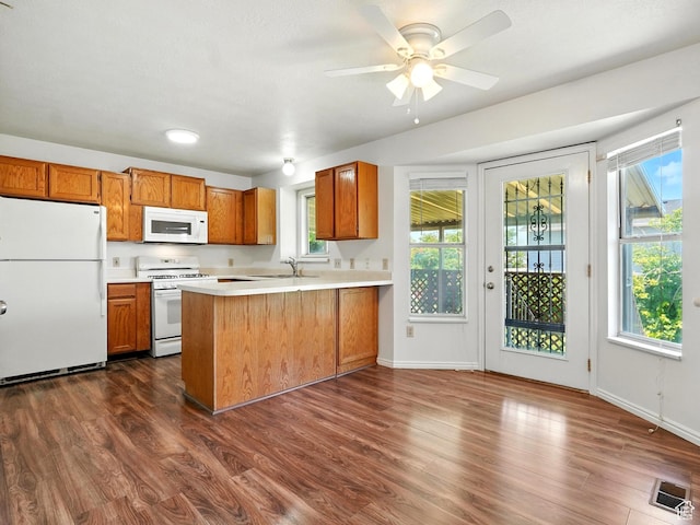 3992 S 4665 W, West Valley City, UT 84120 - kitchen with white appliances, light countertops, brown cabinetry, a peninsula, and dark wood-type flooring